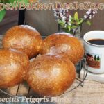 Vier goudbruine no-knead broodjes op rooster — klaar voor koffie en sandwiches.